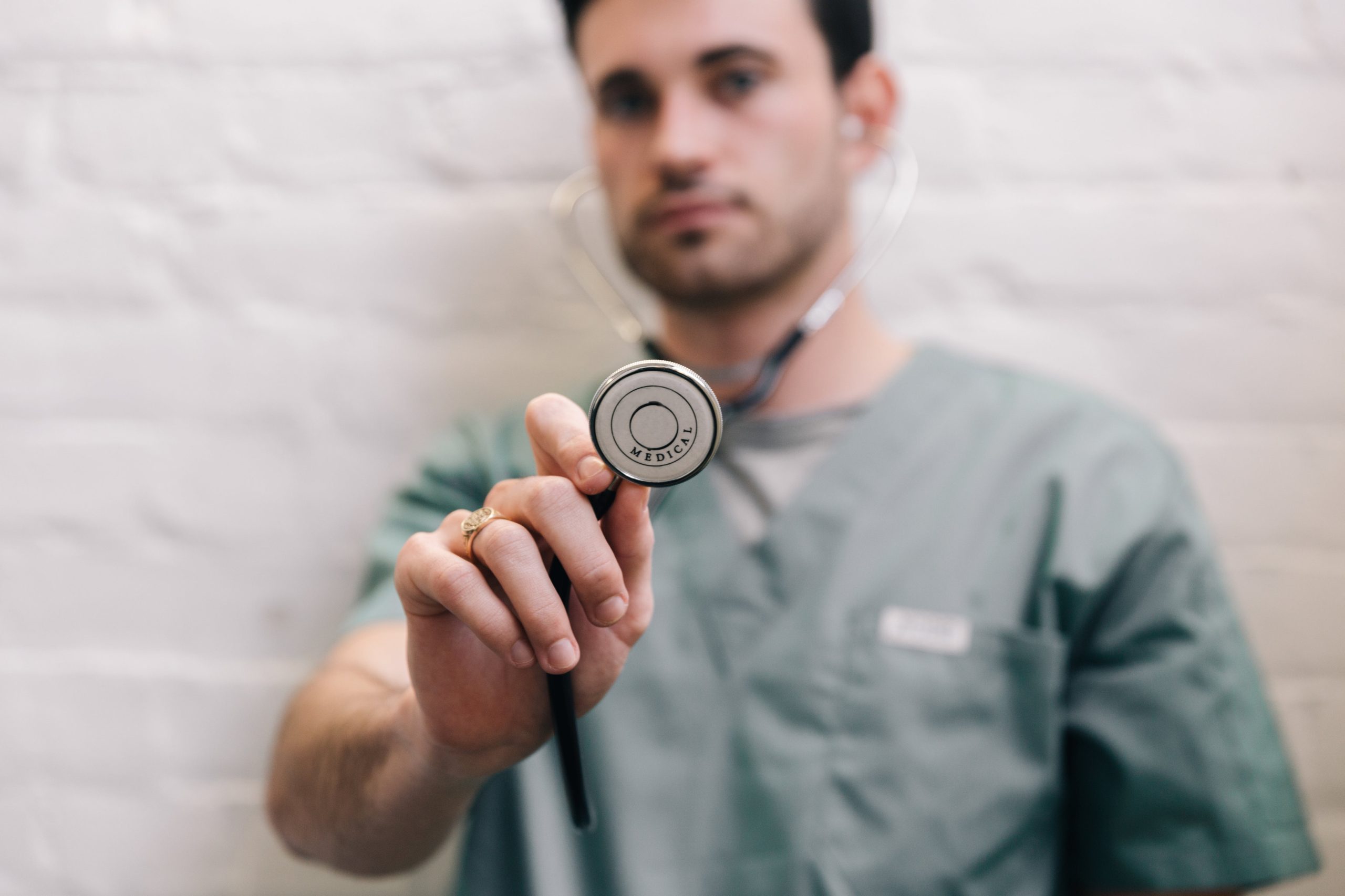 male doctor holding out stethoscope scaled